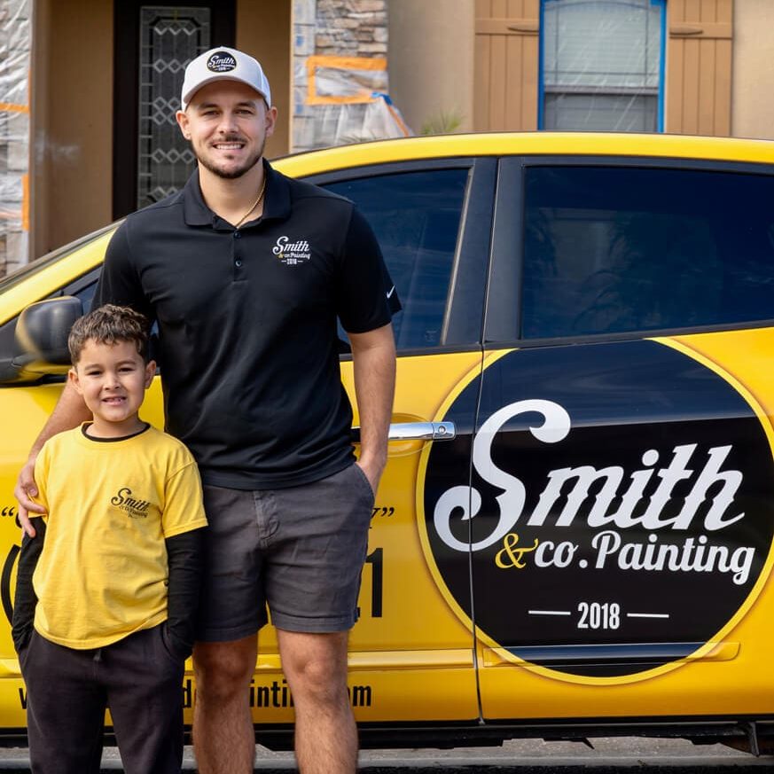 Owner Aiden Smith and his son beside the branded Smith & Co. Painting car